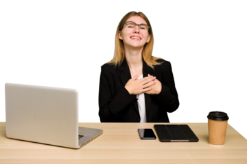 Young business caucasian woman working on her workplace cutout isolated has friendly expression, pressing palm to chest. Love concept.