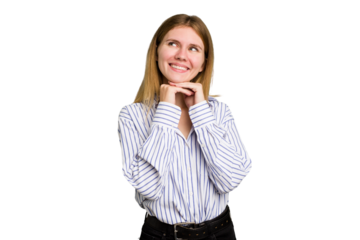 Young caucasian woman isolated keeps hands under chin, is looking happily aside.