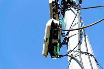 Low angle view of fibre optic network cables in the street on a pillar - open boxes