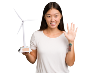 Young asian woman holding a small wind energy mill isolated smiling cheerful showing number five with fingers.