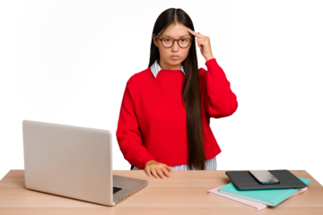 Young student asian woman in a workplace with a laptop isolated pointing temple with finger, thinking, focused on a task.