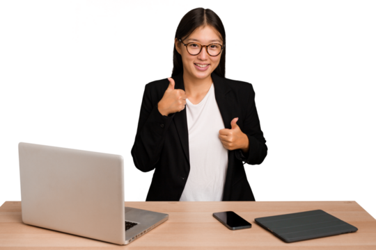 Young business asian woman sitting on a table isolated raising both thumbs up, smiling and confident.