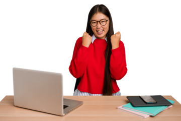Young student asian woman in a workplace with a laptop isolated cheering carefree and excited. Victory concept.