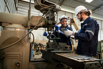 Team of engineers practicing maintenance Taking care and practicing maintenance of old machines in the factory so that they can be used continuously.