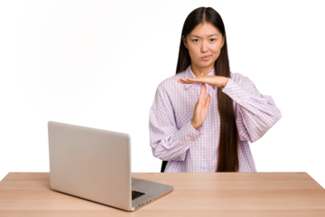 Young student asian woman in a workplace with a laptop isolated showing a timeout gesture.