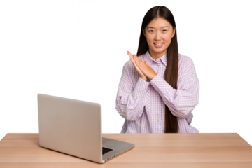 Young student asian woman in a workplace with a laptop isolated feeling energetic and comfortable, rubbing hands confident.