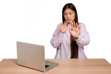 Young student asian woman in a workplace with a laptop isolated being shocked due to an imminent danger