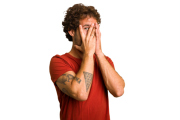 Young curly smart caucasian man cut out isolated blink through fingers frightened and nervous.