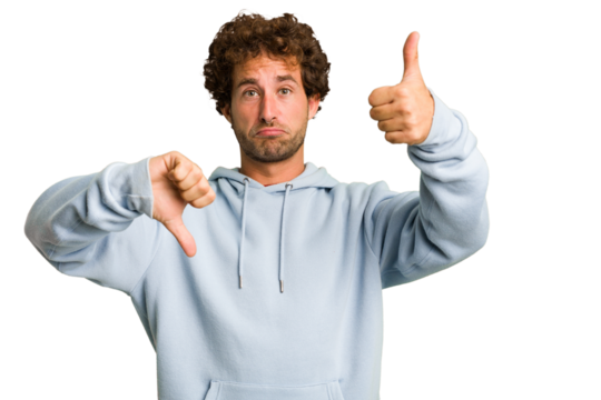 Young curly smart caucasian man cut out isolated showing thumbs up and thumbs down, difficult choose concept