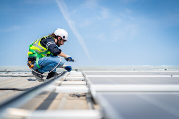 Male engineer installing or checking the working condition of solar panels on the roof or at the...