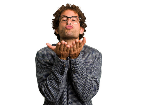 Young curly smart caucasian man cut out isolated folding lips and holding palms to send air kiss.