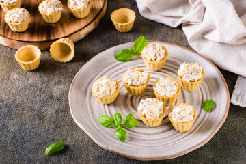 Mini tartlets with a salad of eggs, canned fish and mayonnaise on a plate. Homemade snacks