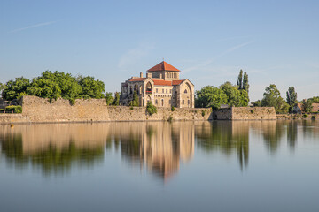 Obraz premium Dam castle on lake water reflecting on surface. trees and blue sky reflection, Ancient fort