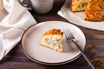 A piece of kurnik pie with chicken, potatoes and rice on a plate. Homemade pastries © elenarui