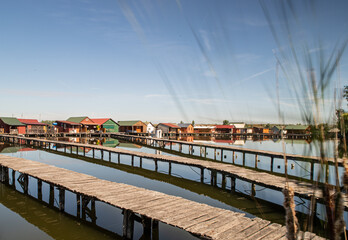 Oriental village on a canal. Houses on stilts. Flooded houses Floating village. Paths on water
