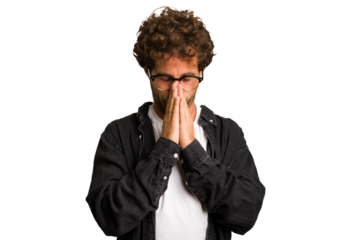 Young curly smart caucasian man cut out isolated praying, showing devotion, religious person looking for divine inspiration.
