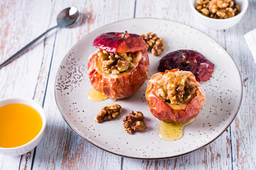 Homemade baked apples with walnuts and honey on the table