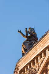 Obraz premium Beautiful statue with rised hand on the Aubette building in central Strasbourg Place Kleber - blue sky in the background