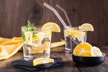 Water with lemon and rosemary in glasses on the table. Detox drink