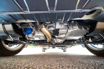 Car bottom view, part of catalytic converter in automobile exhaust system. Engine oil filter and...