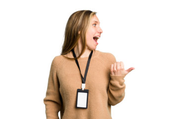 Young caucasian woman with ID card isolated points with thumb finger away, laughing and carefree.