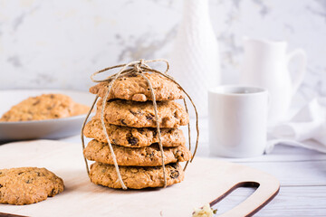 A stack of homemade oatmeal raisin cookies tied with string on a board. Healthy baking.
