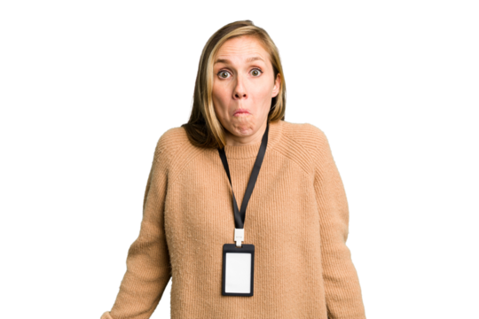 Young caucasian woman with ID card isolated shrugs shoulders and open eyes confused.