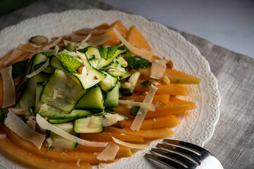 Refreshing and healthy salad with shaved zucchini and sliced melon. Garnished with fresh mint, almonds, and parmesan cheese.