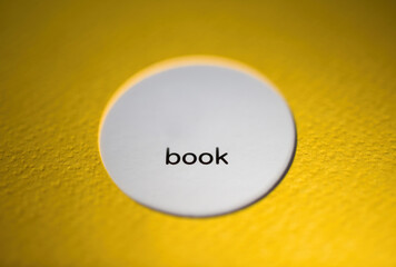 Book brochure text on the white circle with yellow cover jacket