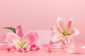 Fototapeta na wymiar Empty podium with lily flowers and festive ribbon on pink background. Showcase for product, gift, perfume and cosmetic presentation, holidays concept