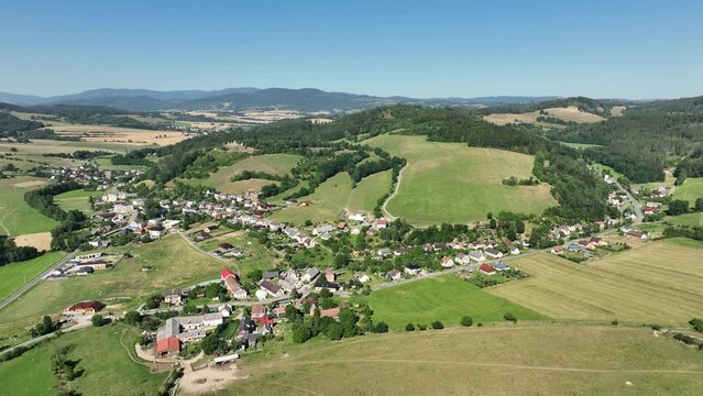 Bio Pastures mountain horses cattle, cows organic sheep and goats, the ruins of the Brnicko castle village forest wood pasture Jeseniky view drone aerial Brnicko houses graze grass scenery cottage