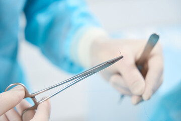 Well-trained surgeon operating medical suturing tools with care and precision
