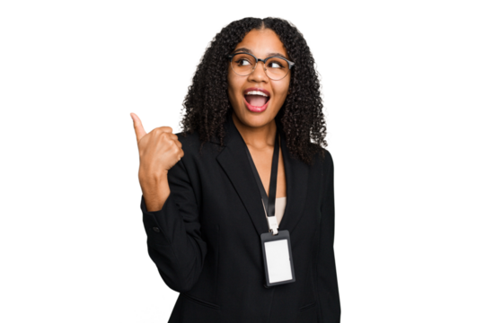 Young african american business woman with ID card isolated points with thumb finger away, laughing and carefree.