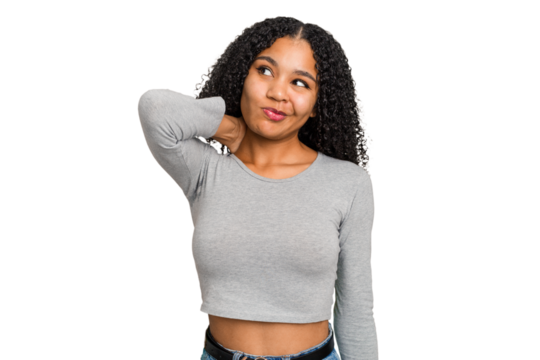 Young african american woman with curly hair cut out isolated touching back of head, thinking and making a choice.