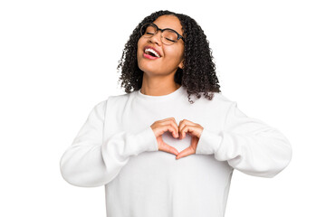 Young african american woman with curly hair cut out isolated smiling and showing a heart shape...