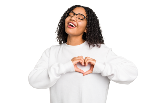 Young african american woman with curly hair cut out isolated smiling and showing a heart shape with hands.