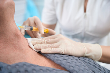 Well-trained medic performing a skin rejuvenation injection for clinic patient