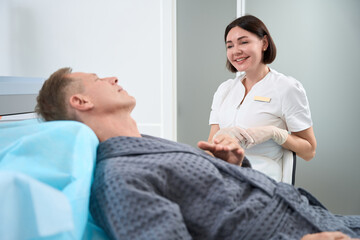 Obraz premium Friendly medical personnel interacting with man in chair