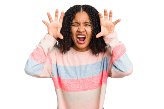 Young african american woman with curly hair cut out isolated showing claws imitating a cat, aggressive gesture.