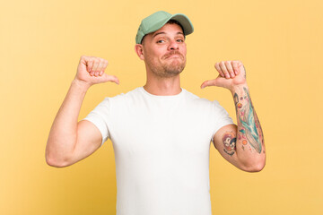 Young caucasian handsome man isolated on yellow background feels proud and self confident, example to follow.