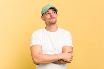 Young caucasian handsome man isolated on yellow background dreaming of achieving goals and purposes