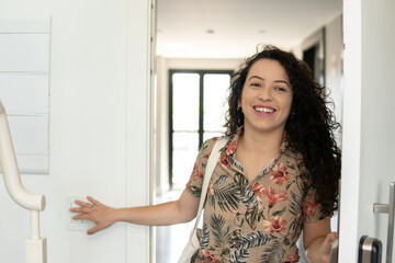 Fototapeta na wymiar Brazilian woman enters home smiling