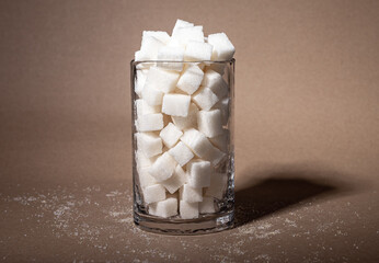 Refined sugar cubes in glass. Danger, harm of white death concept