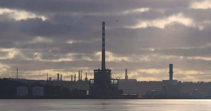 Industrial factory chimey stacks on coast horizon winter clouds landscape