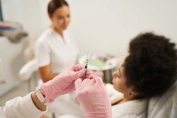 Cosmetologist preparing instruments for beauty injections in salon