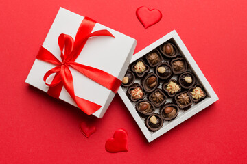 Delicious chocolate pralines in red box for Valentine's Day. Heart shaped box of chocolates top view with copy space