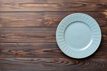 Fototapeta na wymiar Top view of empty grey plate on wooden background. Empty space for your design