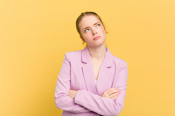 Young caucasian redhead woman isolated on yellow background tired of a repetitive task.