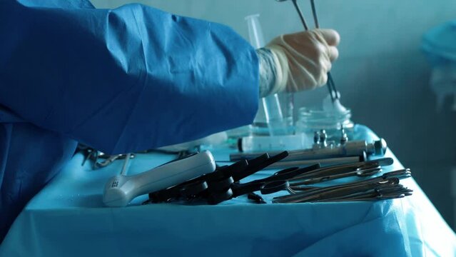The nurse prepares medical devices, scalpels, forceps and others. Surgeons in the operating room are preparing for surgery. Surgical instruments