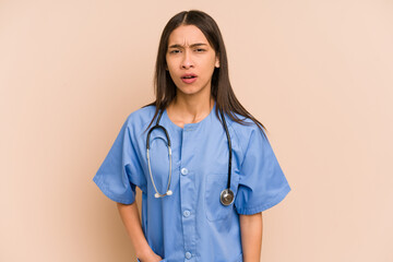 Young nurse colombian woman isolated screaming very angry and aggressive.